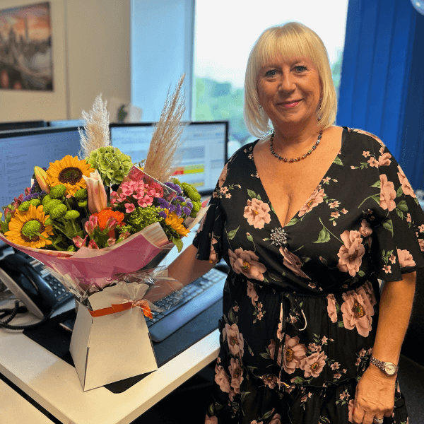 T-T Service Manager Heather with a bouquet of flowers.