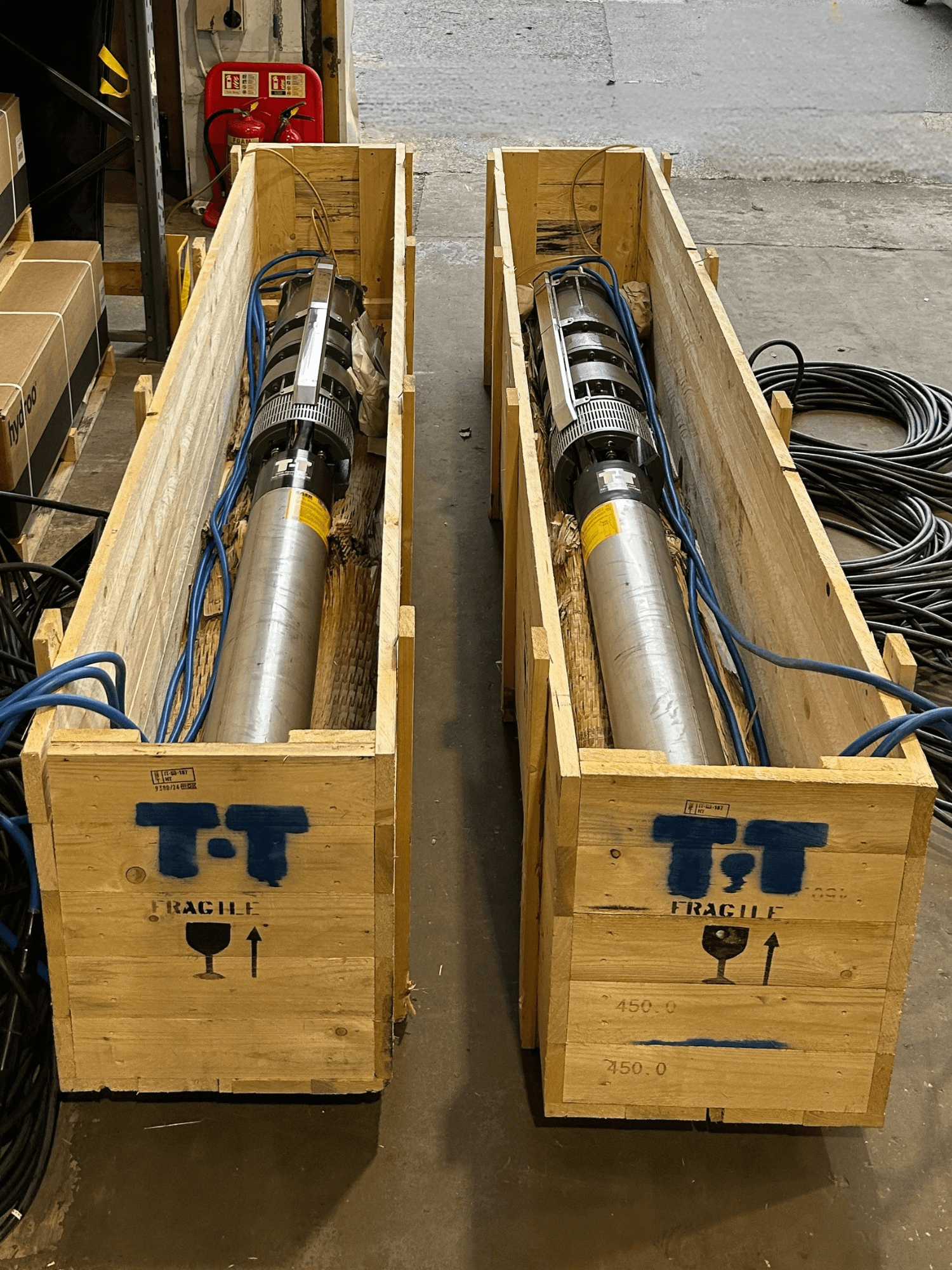 Two boehole pumps in wooden crates.
