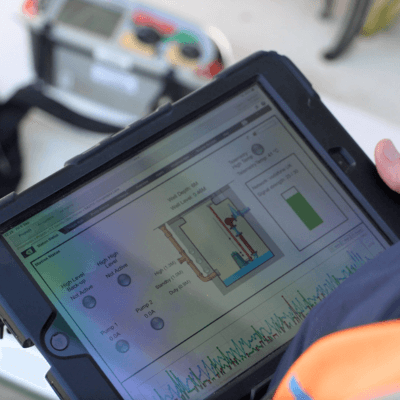 A T-T team member sat at a desk computer and monitoring the liquid level status of a pumping station wet well.